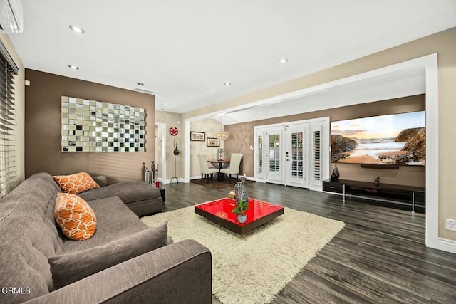 living room with french doors, an AC wall unit, and dark wood-type flooring