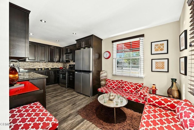 kitchen featuring dark brown cabinets, backsplash, appliances with stainless steel finishes, and dark wood-type flooring