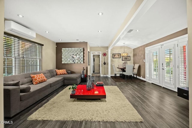 living room with beam ceiling, an AC wall unit, dark wood-type flooring, and french doors