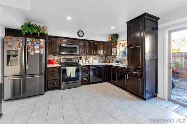 kitchen with sink, light tile patterned floors, dark brown cabinets, stainless steel appliances, and decorative backsplash