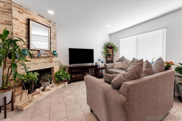 tiled living room with a stone fireplace