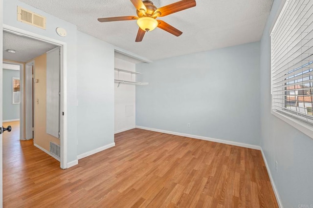 unfurnished room featuring a textured ceiling, ceiling fan, and light hardwood / wood-style flooring