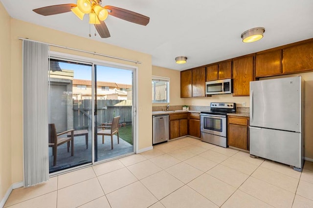 kitchen featuring sink, ceiling fan, light tile patterned floors, and appliances with stainless steel finishes