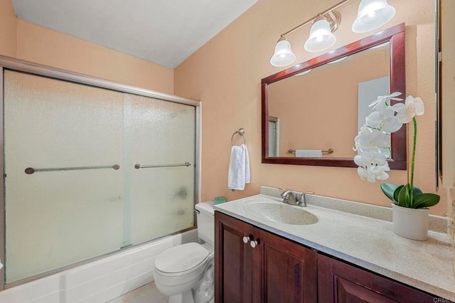 bathroom featuring enclosed tub / shower combo, vanity, and toilet