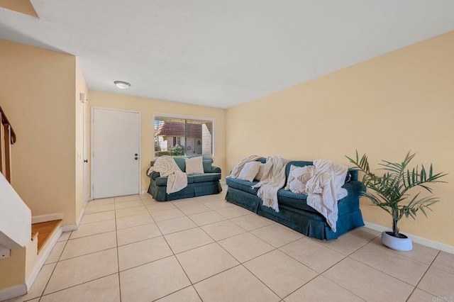 living room featuring stairs, light tile patterned flooring, and baseboards