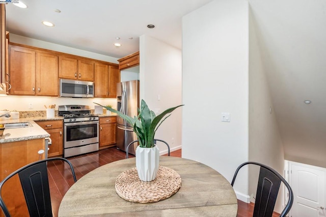 kitchen featuring light stone counters, sink, dark hardwood / wood-style floors, and stainless steel appliances