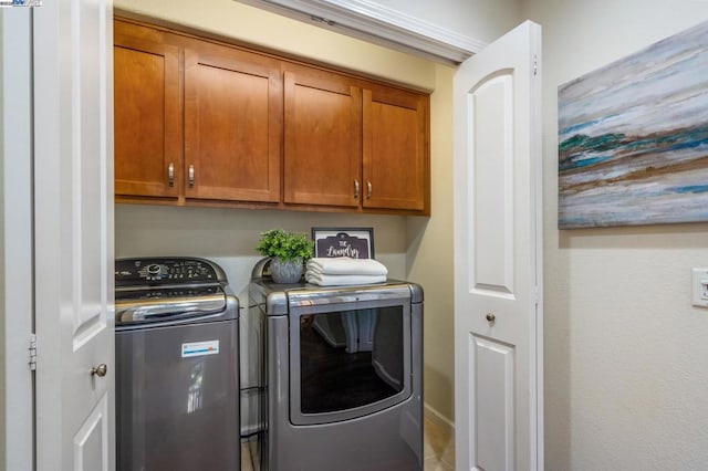 washroom featuring separate washer and dryer and cabinets