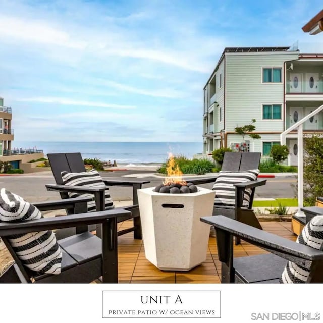 balcony with a water view and an outdoor living space with a fire pit