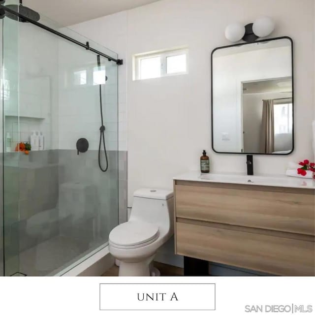 bathroom with vanity, a shower with shower door, and toilet