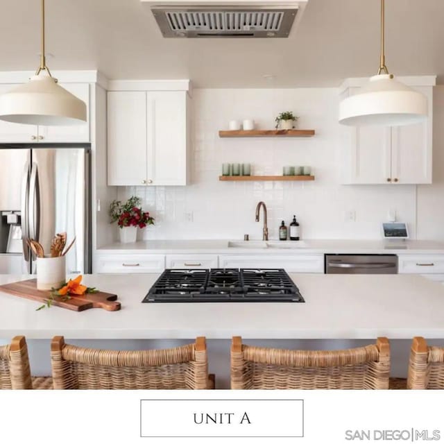 kitchen with pendant lighting, white cabinetry, sink, and stainless steel appliances