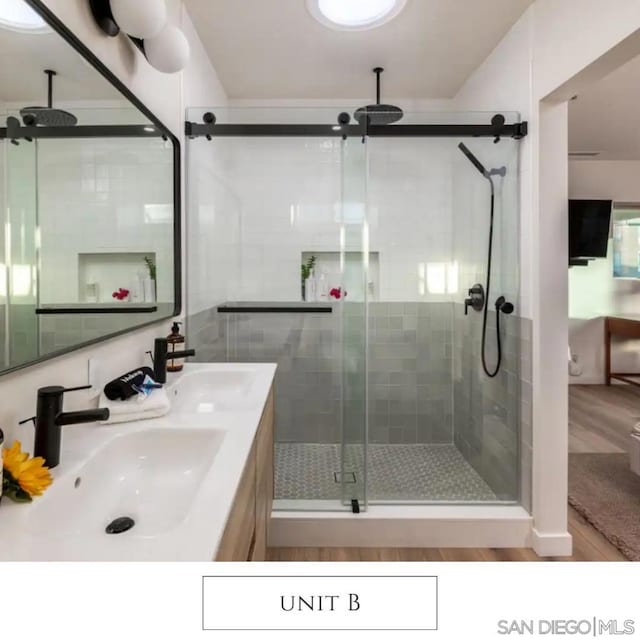 bathroom with a shower with door, vanity, and hardwood / wood-style flooring