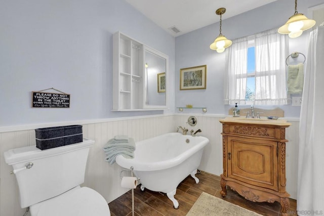 bathroom featuring vanity, toilet, and a tub