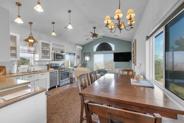 dining area with a wall mounted air conditioner, plenty of natural light, lofted ceiling, and sink