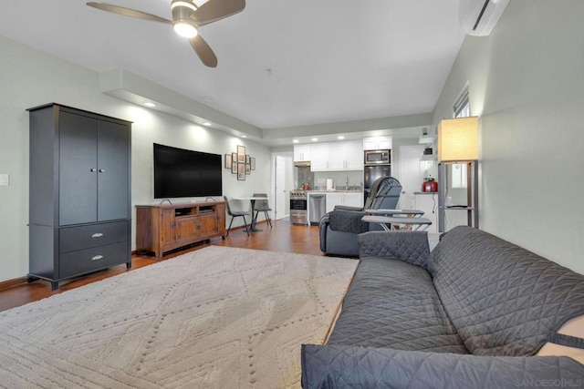 living room with a wall mounted AC, ceiling fan, and dark hardwood / wood-style floors