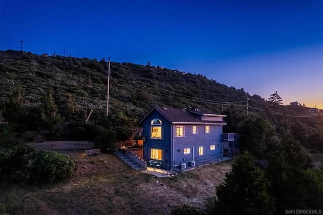 property exterior at dusk featuring a mountain view