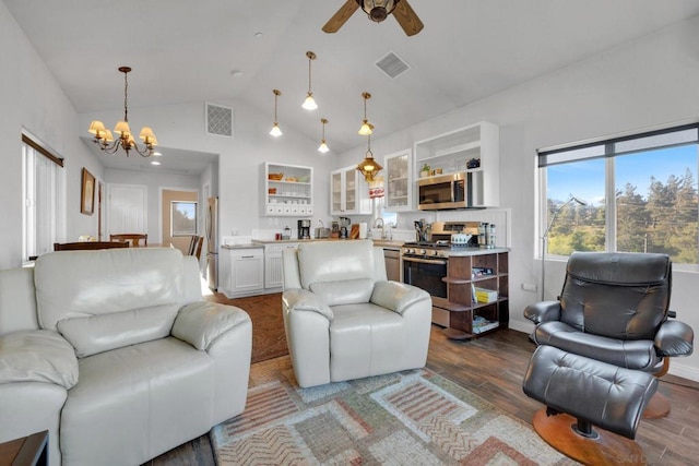 living room with wood-type flooring, ceiling fan with notable chandelier, vaulted ceiling, and sink