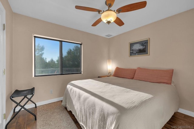 bedroom with dark hardwood / wood-style flooring and ceiling fan