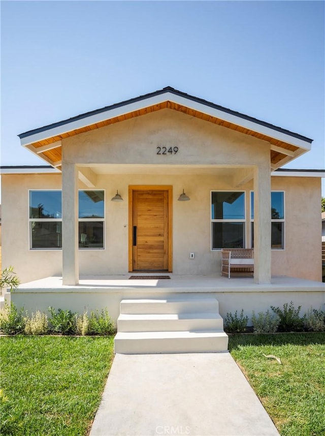 view of front of property featuring a porch and a front lawn