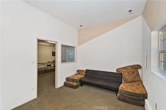 living area featuring carpet flooring and vaulted ceiling