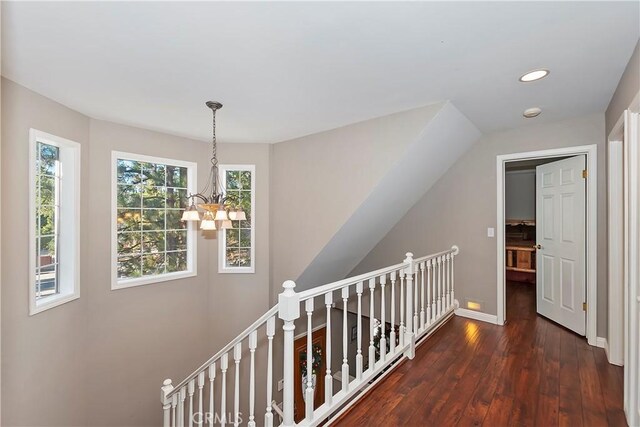 hallway featuring dark hardwood / wood-style floors and an inviting chandelier