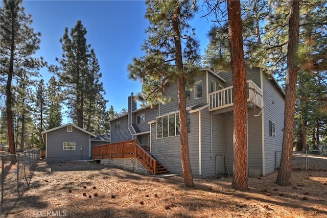 rear view of property featuring a wooden deck