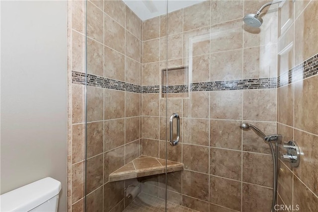 bathroom with toilet and a shower with shower door