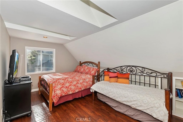 bedroom featuring multiple windows, lofted ceiling with skylight, ceiling fan, and dark wood-type flooring