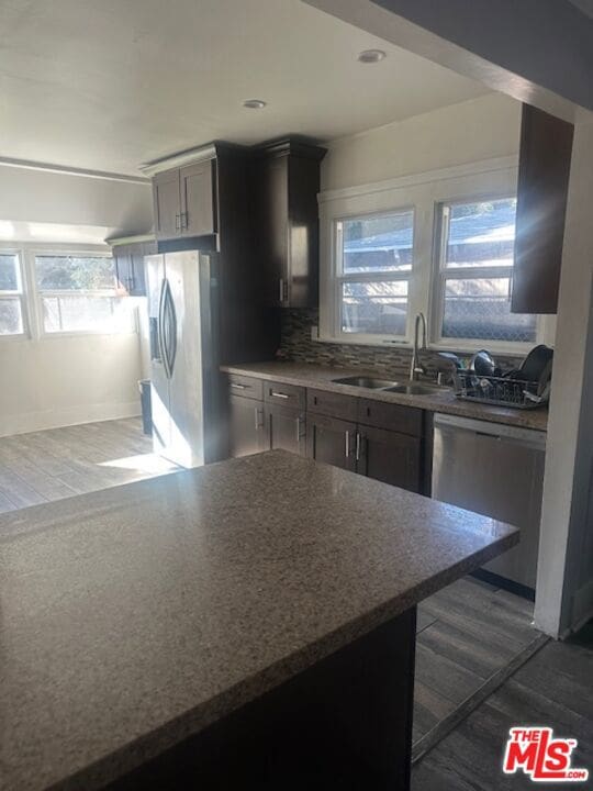 kitchen featuring backsplash, stainless steel appliances, dark hardwood / wood-style floors, and sink