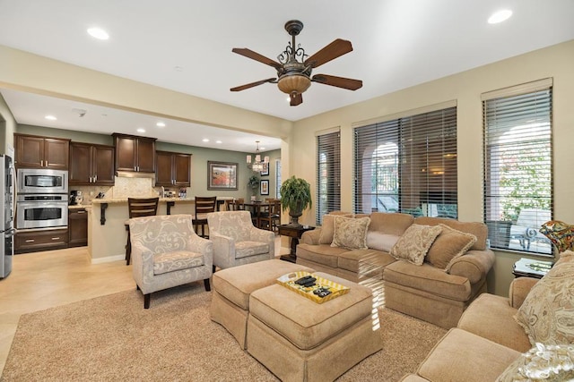 living room featuring ceiling fan with notable chandelier