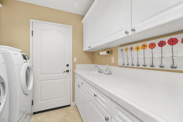 washroom with washer and dryer, light tile patterned flooring, cabinets, and sink