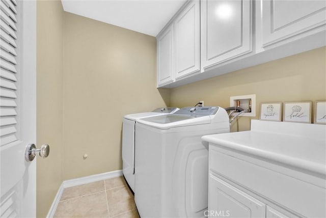 laundry area featuring cabinets, independent washer and dryer, and light tile patterned flooring