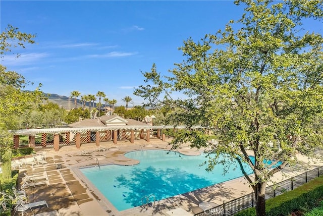 view of swimming pool featuring a mountain view and a patio