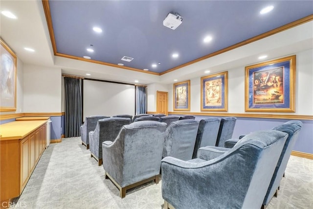 carpeted home theater with a tray ceiling and crown molding