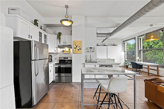 kitchen with pendant lighting, white cabinets, tile patterned floors, stainless steel appliances, and a kitchen breakfast bar