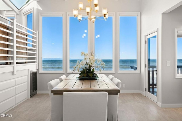 dining area with a notable chandelier, a wealth of natural light, and a water view