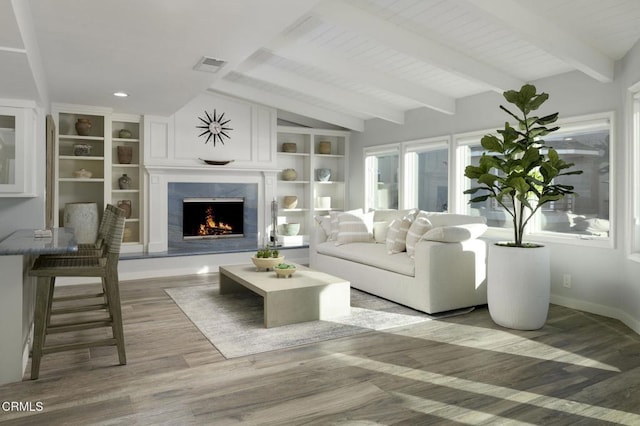 living room featuring a high end fireplace, wood-type flooring, lofted ceiling with beams, and wood ceiling