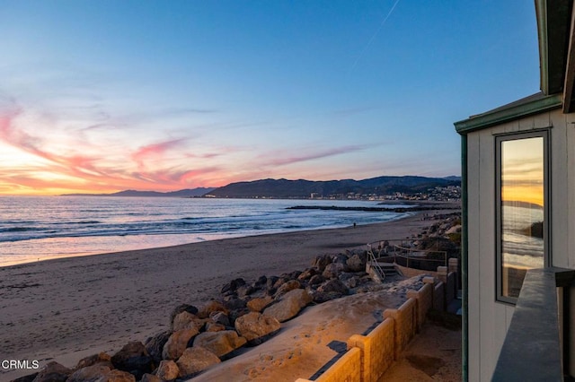 water view with a beach view and a mountain view