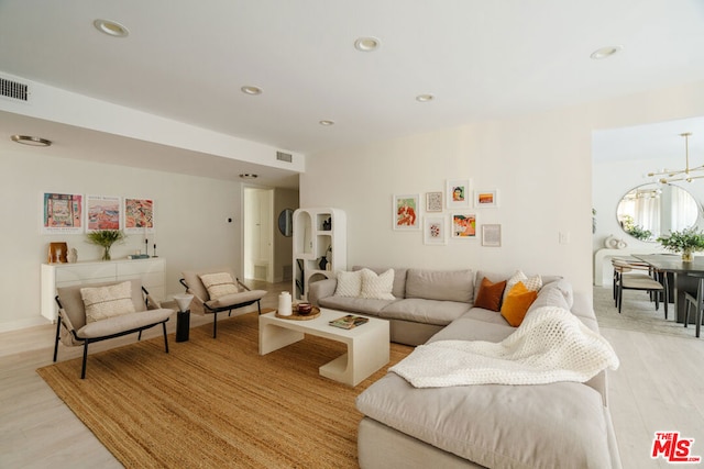 living room with light hardwood / wood-style floors and a chandelier