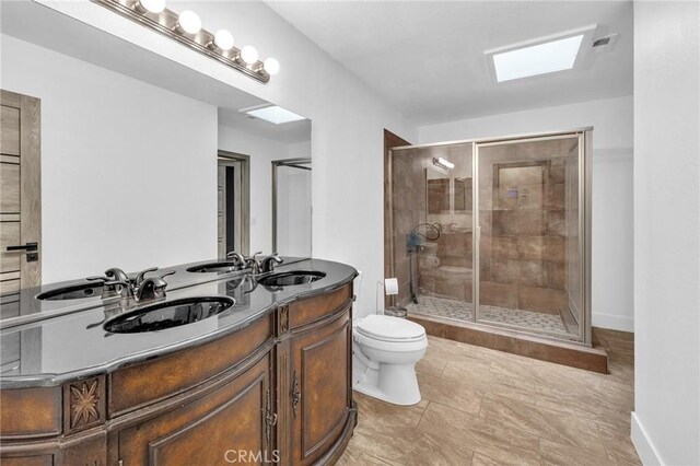 bathroom featuring vanity, toilet, and a shower with shower door