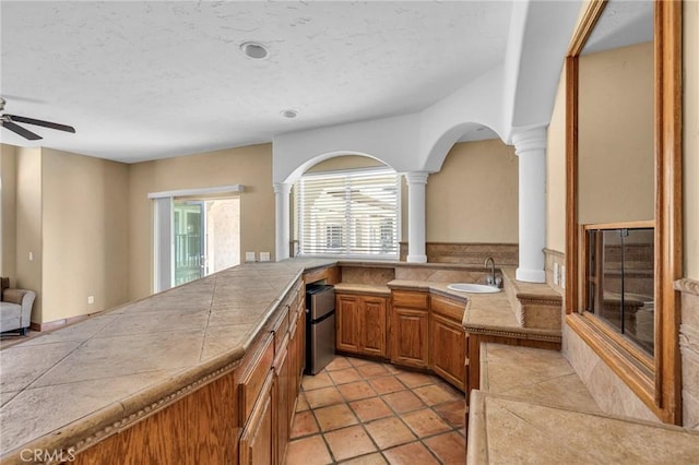 kitchen featuring tile countertops, sink, ceiling fan, fridge, and light tile patterned flooring