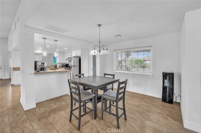 tiled dining room featuring an inviting chandelier