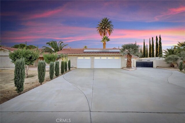 view of front of property featuring solar panels and a garage