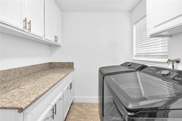 washroom featuring cabinets, light tile patterned flooring, and washer and dryer