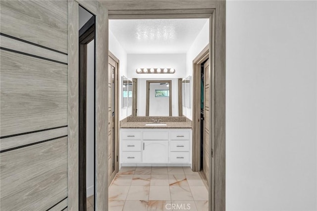 bathroom featuring a textured ceiling and vanity