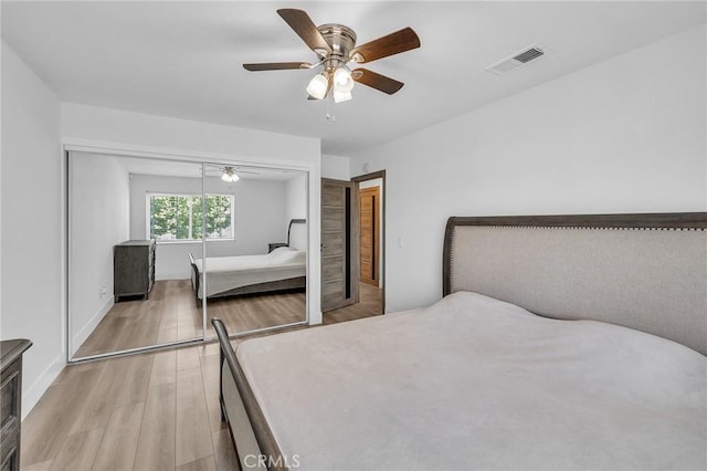 bedroom with ceiling fan, light hardwood / wood-style flooring, and a closet