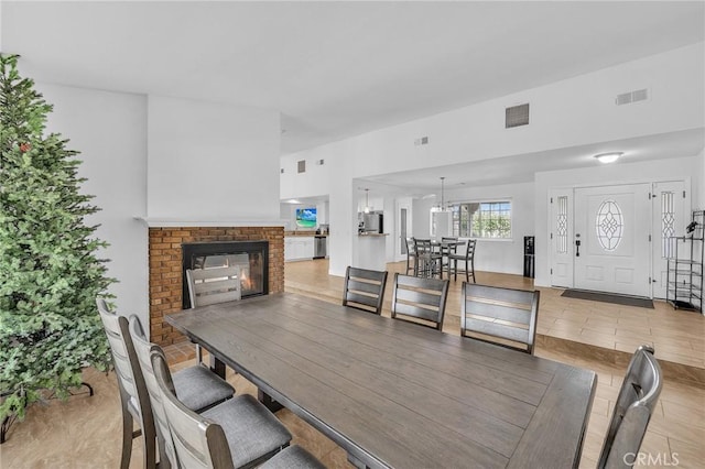 dining room with an inviting chandelier and a brick fireplace