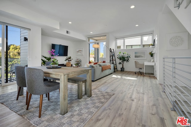 dining area with light hardwood / wood-style floors and plenty of natural light