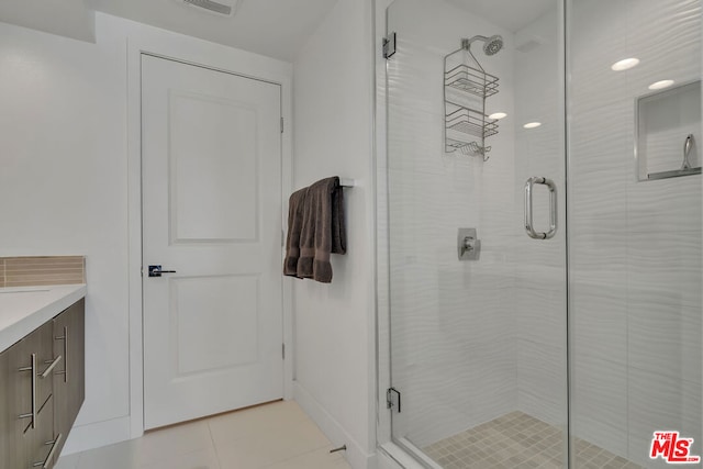 bathroom featuring a shower with door and vanity