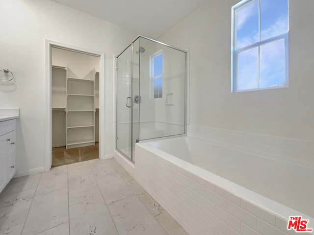 bathroom with vanity and shower with separate bathtub