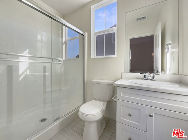 bathroom featuring toilet, tile patterned flooring, an enclosed shower, and vanity